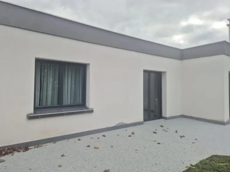 Après travaux : façade réparée avec enduit neuf, fissures invisibles
